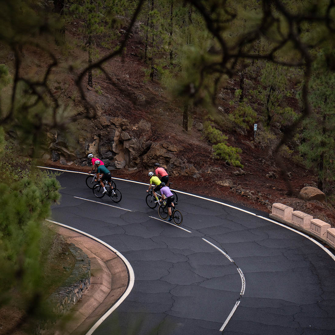 five testers ride road bikes on serpentine road in Tenerife wearing Luxa cycling premium apparel